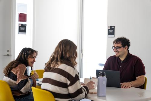 Three General Experimental Psychology students study together at a table.