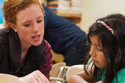 A student teacher helps a student pronounce words by sounding them out.