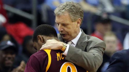 Tim Cluess comforts a basketball player during a game.